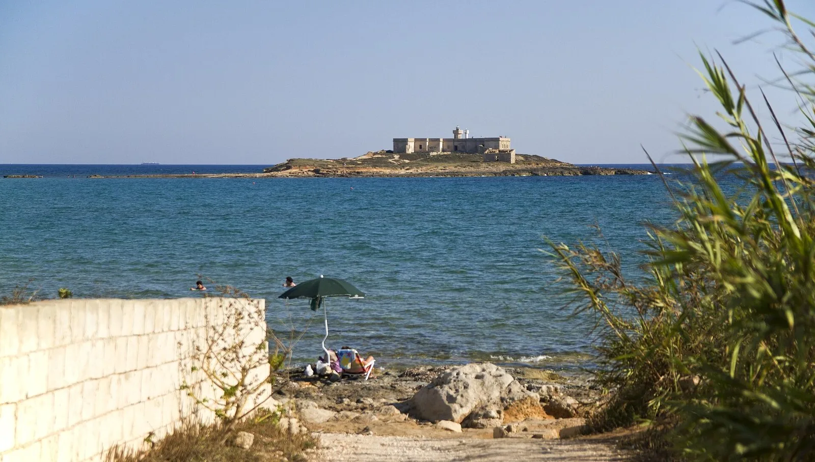 L'Isola delle Correnti vista dalla costa di Portopalo, con il mare basso davanti