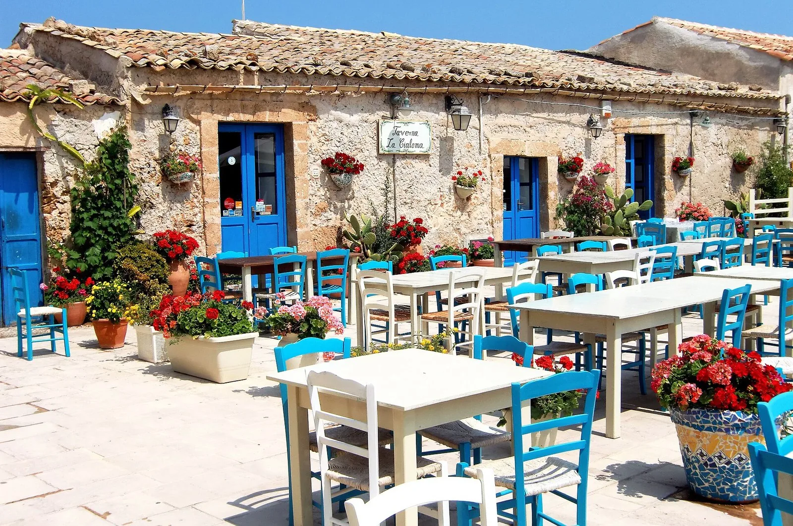 La piazza di Marzamemi con i tavolini e le sedie azzurre davanti alle case in pietra